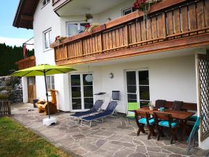 a patio with a table and chairs and an umbrella at Jägerstüble in Altusried