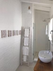 アルツァケーナにあるB&B Li Tauliの白いバスルーム(シンク、タオルハシゴ付)