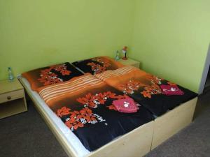 a bed in a room with a bedspread with flowers on it at Hotel Modrá hvězda Sadská in Sadská
