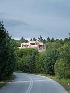 una casa en la cima de una colina con una carretera en Villa Neraida, en Neráïdha