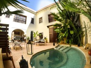 un patio con piscina en una casa en Riad les Ammonites and Spa, en Marrakech
