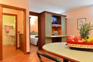 una camera d'albergo con tavolo e cesto di frutta di Residence Del Messaggero a Rovereto