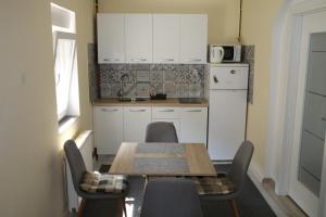 Una cocina con mesa y sillas y un refrigerador. en Apartman Dunav - PARKING - Self check in, en Osijek