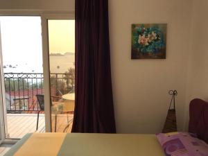 a bedroom with a bed and a view of a balcony at Apartmani Roganovic in Luštica