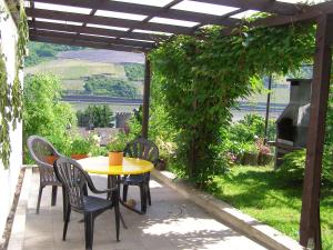 a patio with a table and chairs and an outdoor oven at FeWo Batek in Trechtingshausen