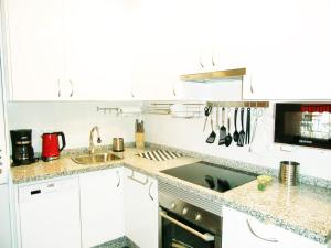 Kuchyňa alebo kuchynka v ubytovaní Apartamento con piscina a 150 metros playa Netflix P Video Aire Acondicionado calefacción toallas y sillas playa sombrilla 2 terrazas una sobre piscina centro ciudad 1 Smart TV por habitación