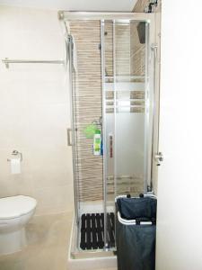 een badkamer met een douche en een toilet. bij Apartamento con piscina a 150 metros playa Netflix P Video Aire Acondicionado calefacción toallas y sillas playa sombrilla 2 terrazas una sobre piscina centro ciudad 1 Smart TV por habitación in Fuengirola