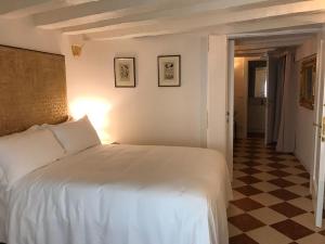 a bedroom with a white bed and a checkered floor at Suites alla Maddalena in Venice