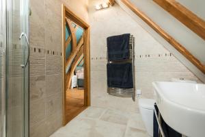 a bathroom with a shower and a sink and a toilet at Corner Farm in Halesworth