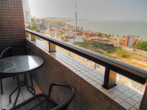 d'un balcon avec une table et une vue sur la ville. dans l'établissement Apartamento Maximum, à Natal