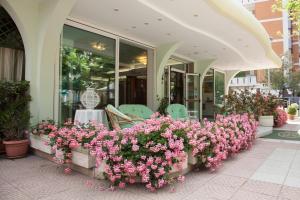 een bos roze bloemen op een patio bij Hotel Ancora in Rimini