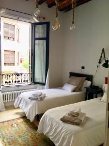 dwa łóżka w pokoju z oknem w obiekcie Apartamento en el centro de Bilbao w mieście Bilbao