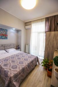 a bedroom with a bed and a large window at Vortex - City Center in Tbilisi City