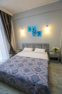 a bedroom with a bed with a blue quilt at Vortex - City Center in Tbilisi City