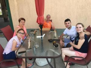 a group of people sitting around a table at Hostel Denisa in Buzău