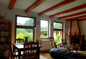 a living room with a table and chairs and windows at Pensiunea Casa Noastra in Baia de Fier