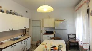 a kitchen with a table and a white refrigerator at Abitazione Morosini Apartment in Venice