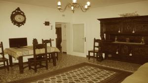 a living room with a table and a clock on the wall at Abitazione Morosini Apartment in Venice