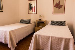 two beds sitting next to each other in a room at Appartamento con terrazza a livello in Quartu SantʼElena