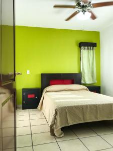 una camera verde con letto e ventilatore a soffitto di Comodo Departamento a Tequila