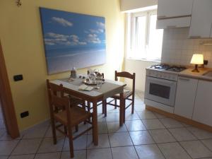 y cocina con mesa, sillas y fogones. en Sea View Apartment, en Catania