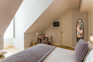 sypialnia z łóżkiem i lustrem w obiekcie Almaria - Da Corte Apartments | Chiado w Lizbonie