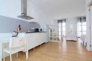 a kitchen and living room with a counter and chairs at Apartamentos Centro Cordoba in Córdoba