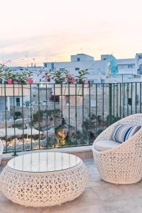 a balcony with a table and chairs and a view of a city at POSEA - Polignano Sea Suites in Polignano a Mare