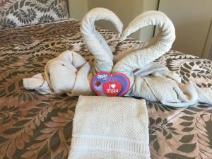 uma cama com toalhas e um coração e dois cisnes em Invicta House Maia em Maia