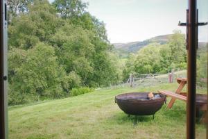 a bbq grill in a field next to a fence at Howe of Torbeg in Ballater