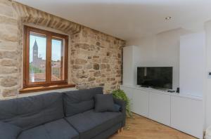 a living room with a blue couch and a window at Vila Magdalena in Supetar