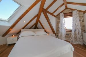 a bedroom with a white bed in a attic at Vila Magdalena in Supetar