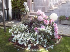 a flower garden with pink and white flowers in a yard at B&B LE MAGNOLIE in Gallarate