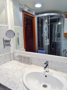 un bagno con un lavandino e un grande specchio di Centro y playa a La Coruña