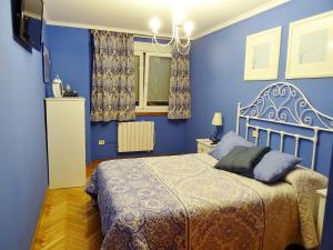 Dormitorio azul con cama y ventana en Centro y playa, en A Coruña