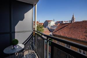 Un balcón con una mesa y vista a la ciudad. en Apartment Eugen II, en Novi Sad