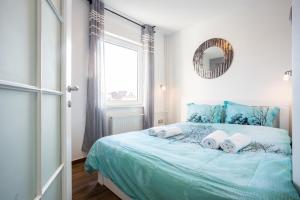 1 dormitorio con cama azul, espejo y ventana en Apartment Eugen II, en Novi Sad