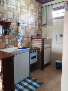 a kitchen with a sink and a stove in it at Estúdio Recanto Dos Anjos in Arraial do Cabo