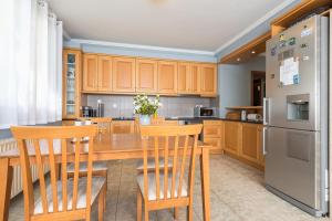 una cocina con armarios de madera y una mesa y sillas de madera. en Athens Countryside resort with pool, en Pallini