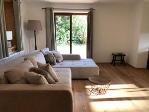 a living room with a couch and a large window at Schneehaus Lodge in Ehrwald