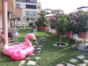 un cisne rosa inflable en el patio de una casa en La Mer Apartments en Tsarevo