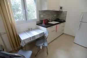 Una pequeña cocina con una mesa y un fregadero. en Olga Beach Apartment 28, en Haifa