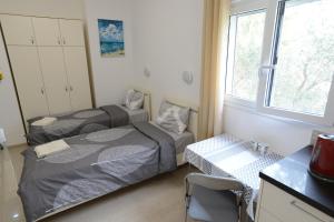 a bedroom with two beds and a desk and a window at Olga Beach Apartment 28 in Haifa