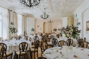 una stanza piena di tavoli e sedie con fiori di Pałac Zdunowo a Załuski