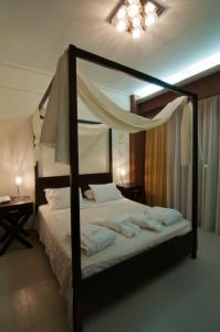 a bedroom with a canopy bed with towels on it at Riviera Perdika Hotel in Perdika