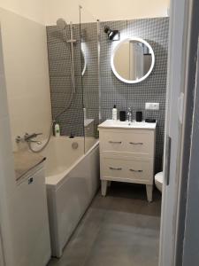 a bathroom with a tub and a sink and a mirror at 2 Bedroom City Center Apartment in Katowice