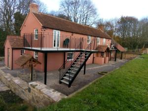 a pink house with a staircase in front of it at Pershbrook Cottage & Garden in Oakle Street
