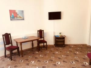 a room with a table and two chairs and a television at Metropol in Rostov on Don