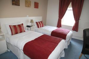 a hotel room with two beds and a window at Dalton Inn Hotel in Claremorris