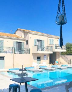 a house with a swimming pool in front of a building at Villa Olga Lounge Hotel in Lygia